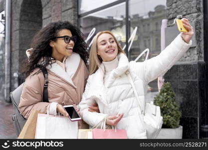 medium shot smiley women taking selfie
