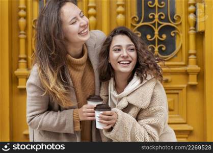 medium shot smiley women with coffee cups