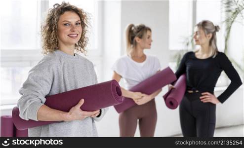 medium shot smiley women with yoga mats