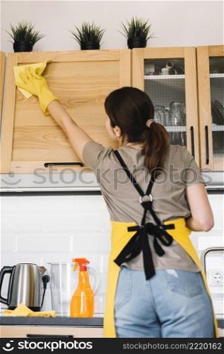 medium shot woman cleaning cabinet