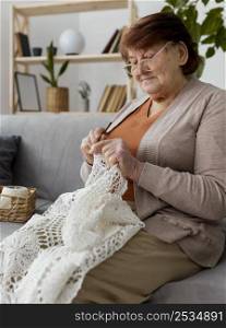 medium shot woman crocheting couch