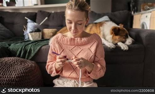 medium shot woman crocheting with dog