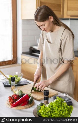 medium shot woman cutting cucumber