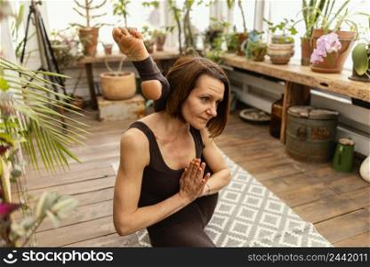 medium shot woman doing yoga