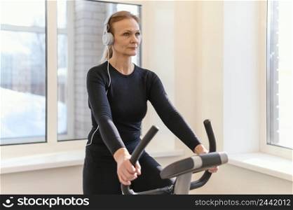 medium shot woman exercising spin bike