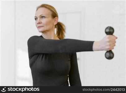 medium shot woman exercising with dumbbell