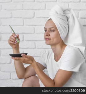 medium shot woman holding aloe vera