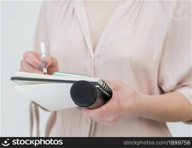medium shot woman holding microphone writing notes. Resolution and high quality beautiful photo. medium shot woman holding microphone writing notes. High quality beautiful photo concept