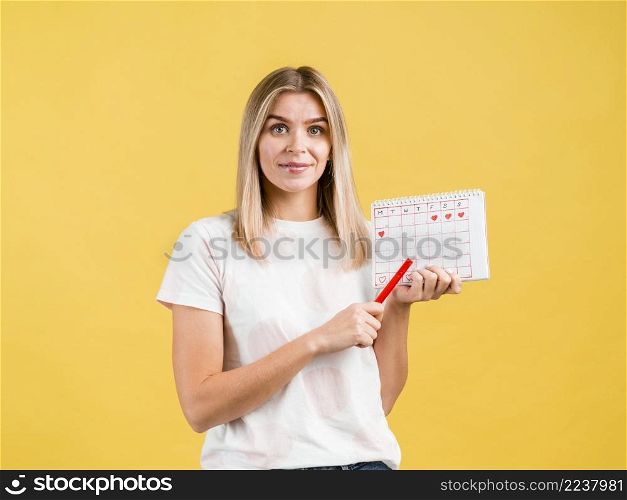 medium shot woman holding pen period calendar