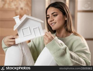 medium shot woman holding small house 2