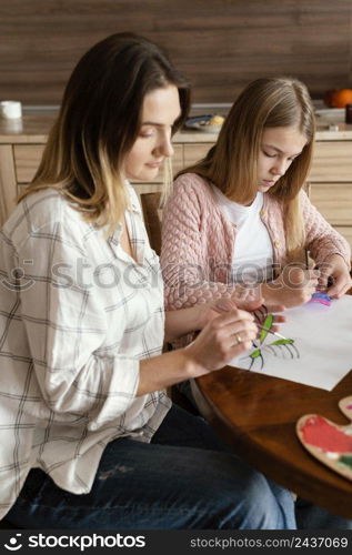 medium shot woman kid painting butterflies