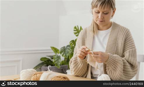 medium shot woman knitting home
