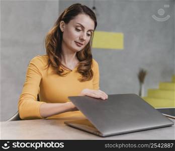medium shot woman opening laptop