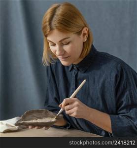 medium shot woman painting leaf