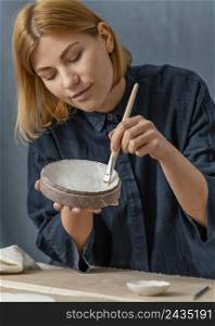 medium shot woman painting vase