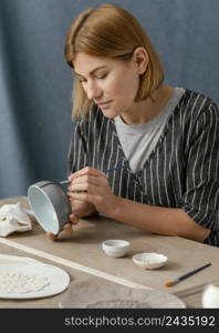 medium shot woman painting with brush 2