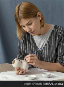 medium shot woman painting with brush