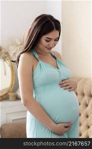 medium shot woman posing indoors during pregnancy