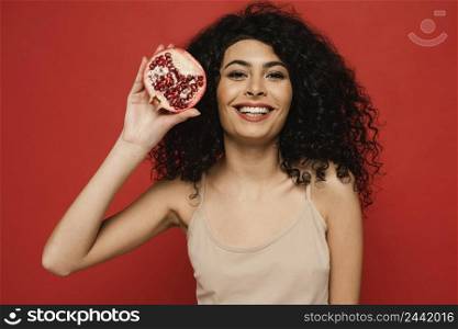 medium shot woman posing with pomegranate