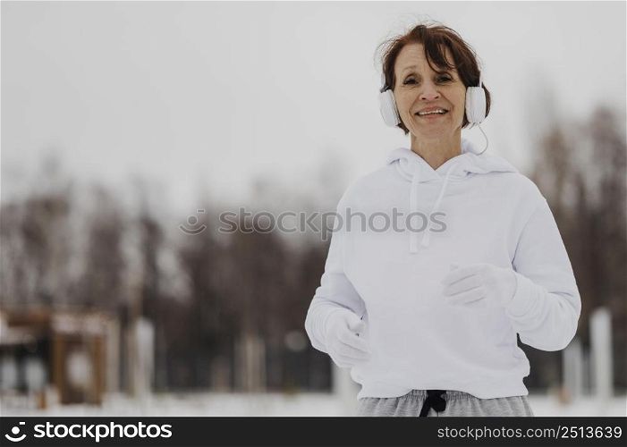 medium shot woman running with headphones