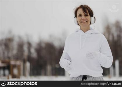 medium shot woman running with headphones