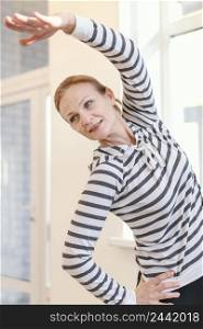 medium shot woman stretching indoors