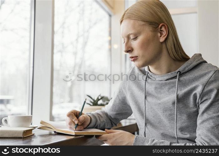 medium shot woman writing notebook