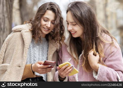 medium shot women holding smartphones