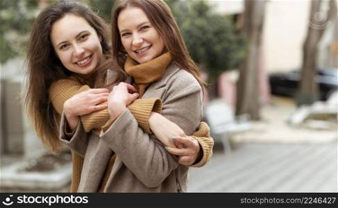 medium shot women hugging outdoors