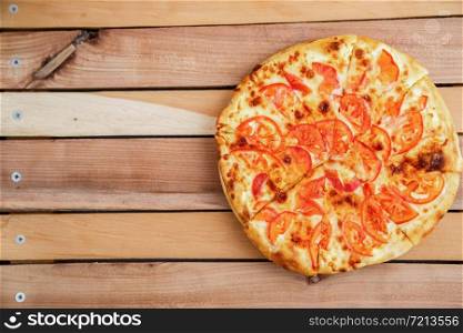 medium-sized pizza with tomatoes on a wooden tray