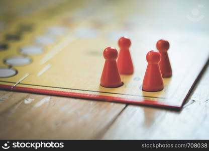 Meeples on a board, ready for playing a parlor game, ludo