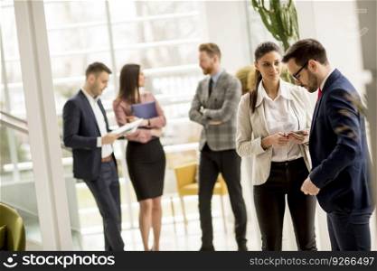 Meeting of group of businesspeople in the office standing in front of  large window in modern office