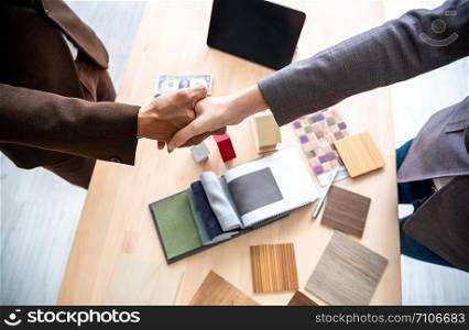 Meeting of Insurance agent and customer shaking hand after signing contract for realty purchase in office.Bank employee congratulate.Home loan approval,insurance mortgage,real estate concept.Top view