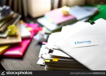 Meeting; Stack of Documents. Working or Studying at messy desk.