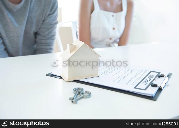 Meeting with agent in office, buying renting apartment or house, buyers of real estate ready to conclude a deal, family couple shaking hands with realtor after signing documents for realty purchase