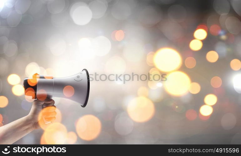 Megaphone in hand. Close up of human hand holding megaphone