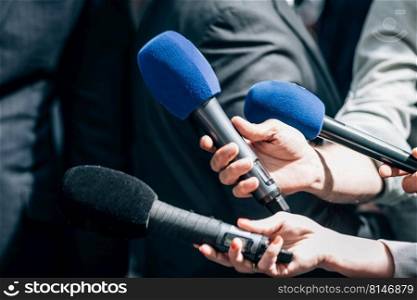 Meida microphones. News reporters holding microphones, taking an official statement. Media interview, a politician at media press conference.