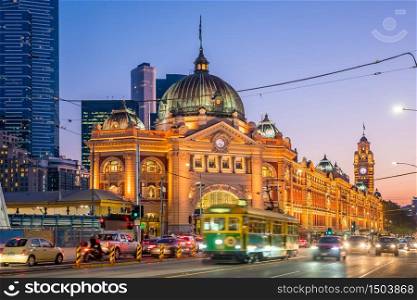 Melbourne Flinders Street Train Station with moving tram in Australia at sunset