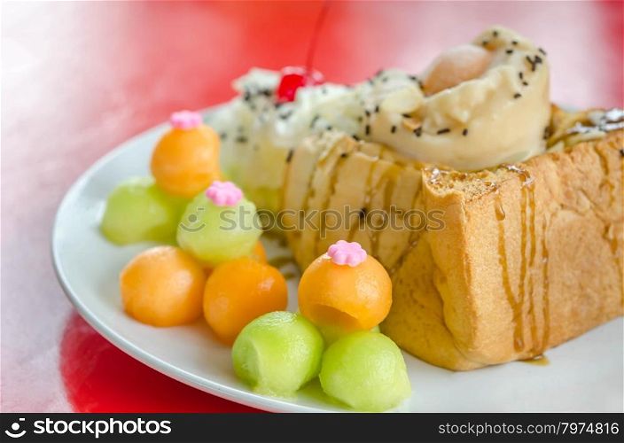 Melon toast. Honey toast topped with ice cream cantaloupe and melon on dish