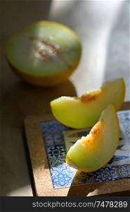 Melon with slices on a wooden table