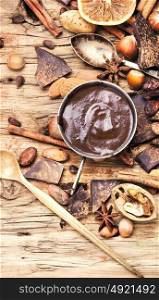 Melting chocolate,spice and nuts. cup with melted hot chocolate, cocoa beans, nuts and spices
