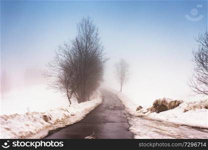 Melting Snow on mountain country road in Carpathians. Weather forecast for early spring. Difficult road. Early spring in temperate climate. Spring coming