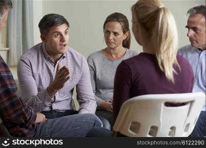 Members Of Support Group Sitting In Chairs Having Meeting