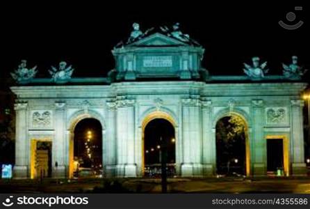Memorial gate lit up at night, Alcala Gate, Madrid, Spain