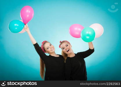 Memory of childhood and forgotten dreams. Two cute lovely retro styled women behave like little girls. Adults trying to fly away by balloons to dream come true.. Women like a little girls want fly away by balloons.