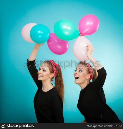 Memory of childhood and forgotten dreams. Two cute lovely retro styled women behave like little girls. Adults trying to fly away by balloons to dream come true.. Women like a little girls want fly away by balloons.