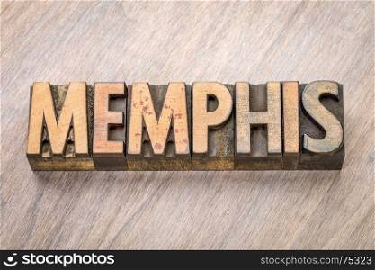 Memphis word abstract in vintage letterpress wood type against grained wooden background