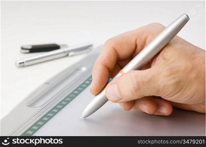 Men&acute;s hand draws on the graphic tablet