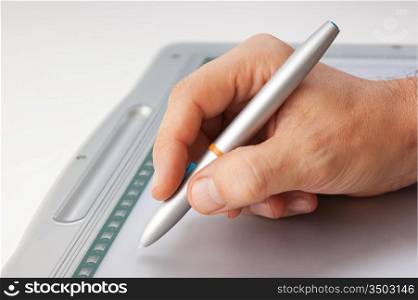 Men&acute;s hand draws on the graphic tablet PC