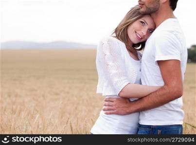 Men and woman hugging in the grass